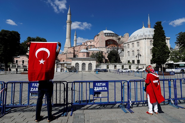 People carry Turkish flags outside the Hagia Sophia or Ayasofya, a UNESCO World Heritage Site, which was a Byzantine cathedral before being converted into a mosque and currently a museum, in Istanbul